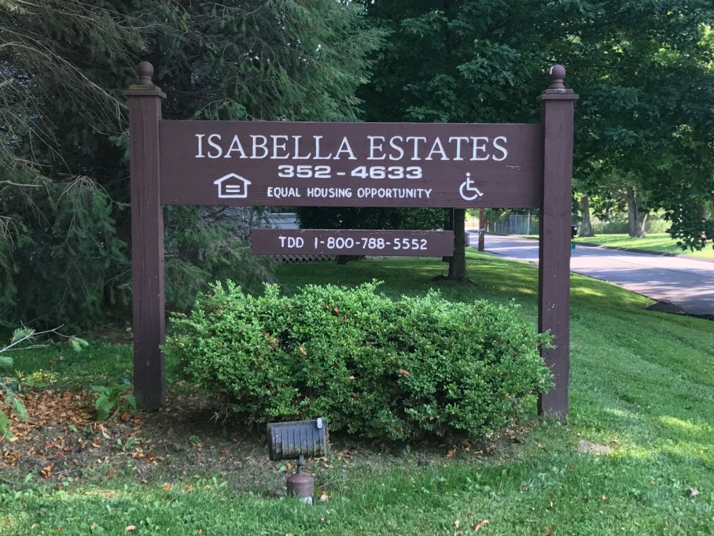the sign for isabela estates in front of a park