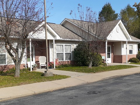 a brick house with a sidewalk in front of it