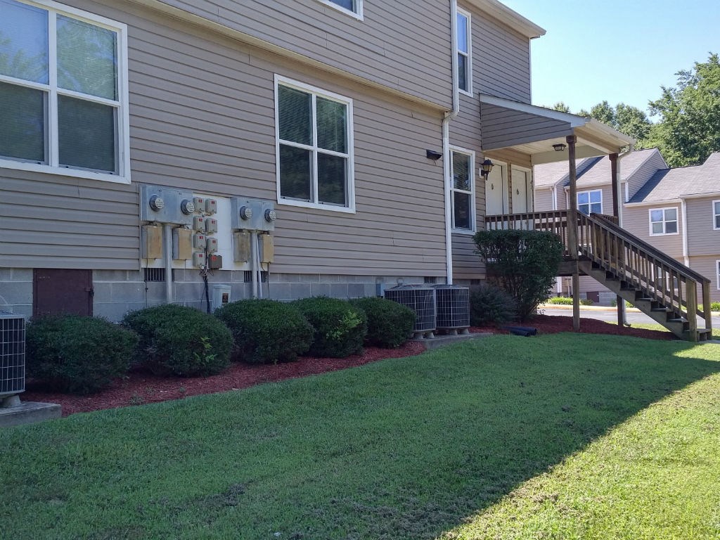 the front of a house with a yard and a staircase