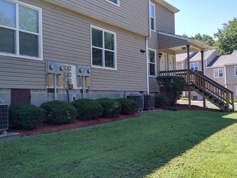 the front of a house with a yard and a staircase