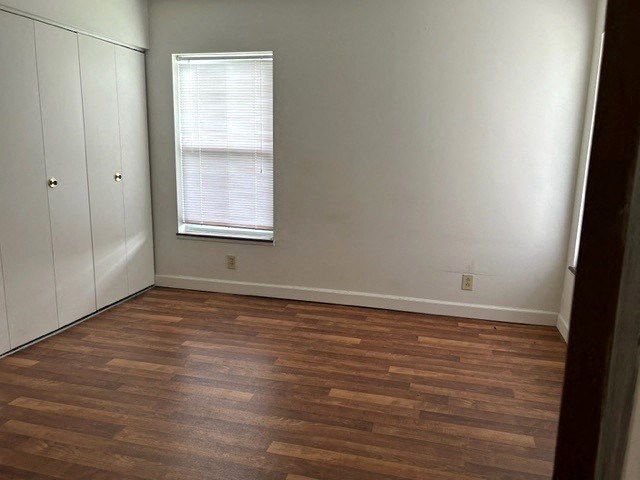 an empty room with a wood floor and a window