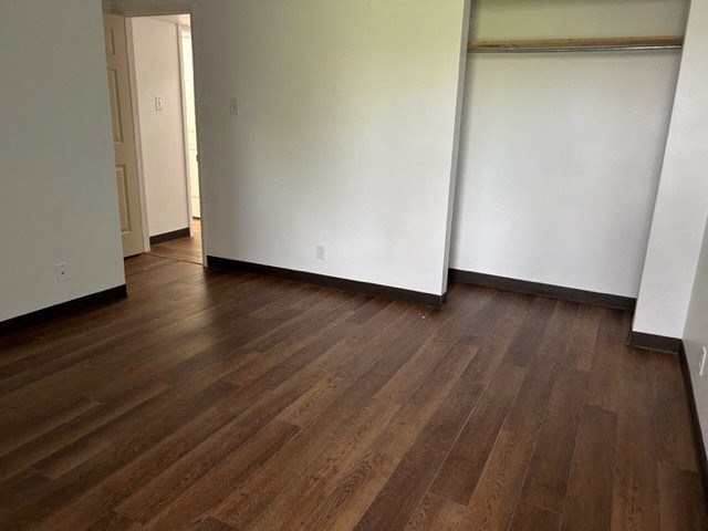 an empty living room with white walls and wood floors