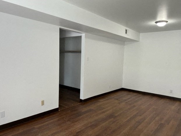 an empty living room with white walls and wood floors