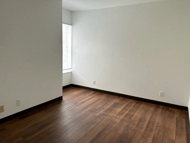 an empty room with wooden floors and white walls
