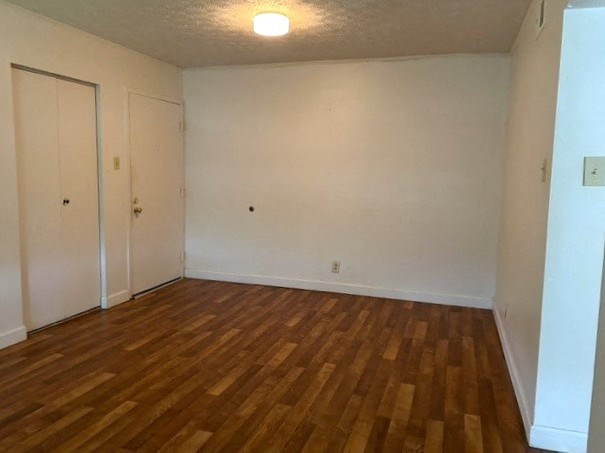 an empty room with a wooden floor and white walls