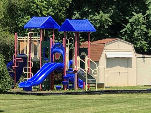 A playground with a blue slide and a red and blue structure.