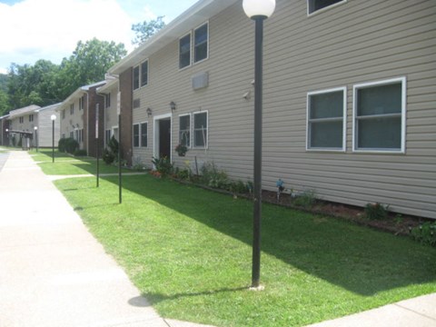 a row of houses with a sidewalk and grass