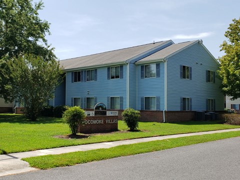 A blue building with a sign that says "Doe Moorook Villages" in front of it.