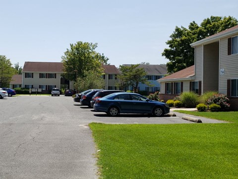 A parking lot with cars and apartment buildings in the background.
