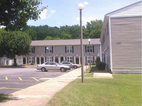 an apartment building with cars parked in a parking lot