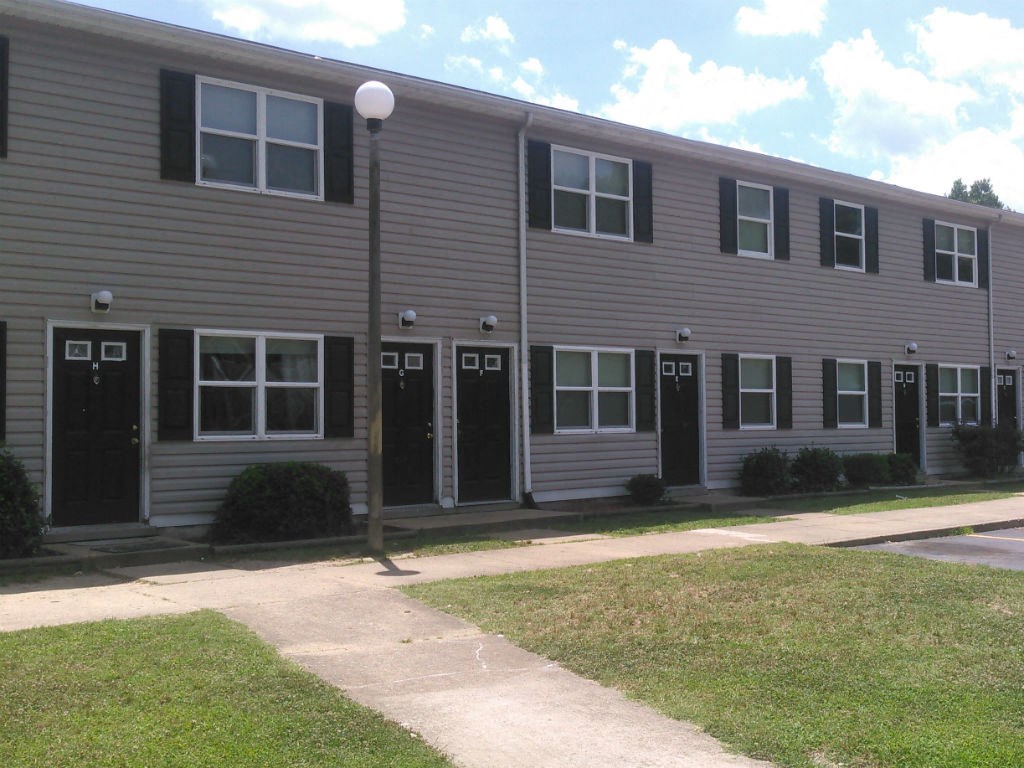 A building with grey siding and black shutters.