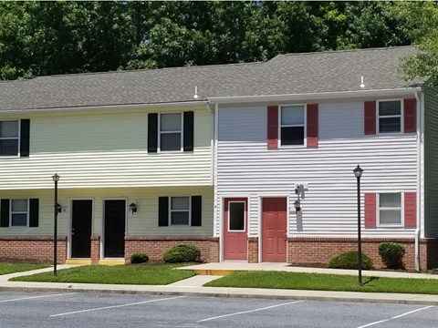 A two-story building with a parking lot in front.