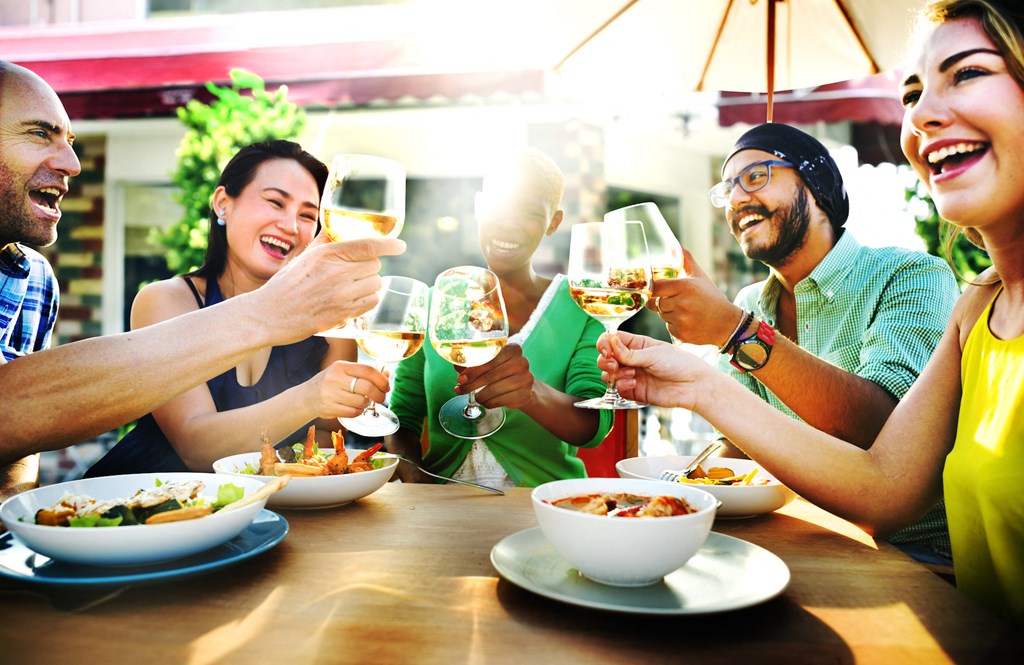 A group of people toasting with wine glasses at a table.