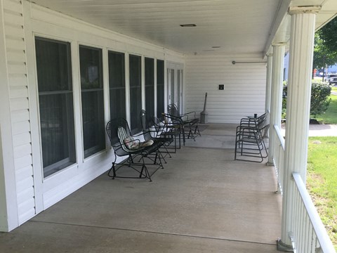 the front porch of a house with rocking chairs