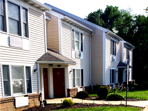 A row of houses with a red door in the front.