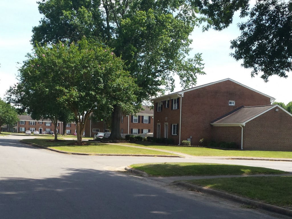 a street in front of a brick building with trees