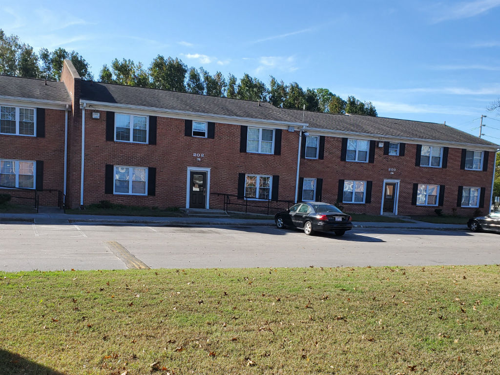 a black car parked in front of a brick building