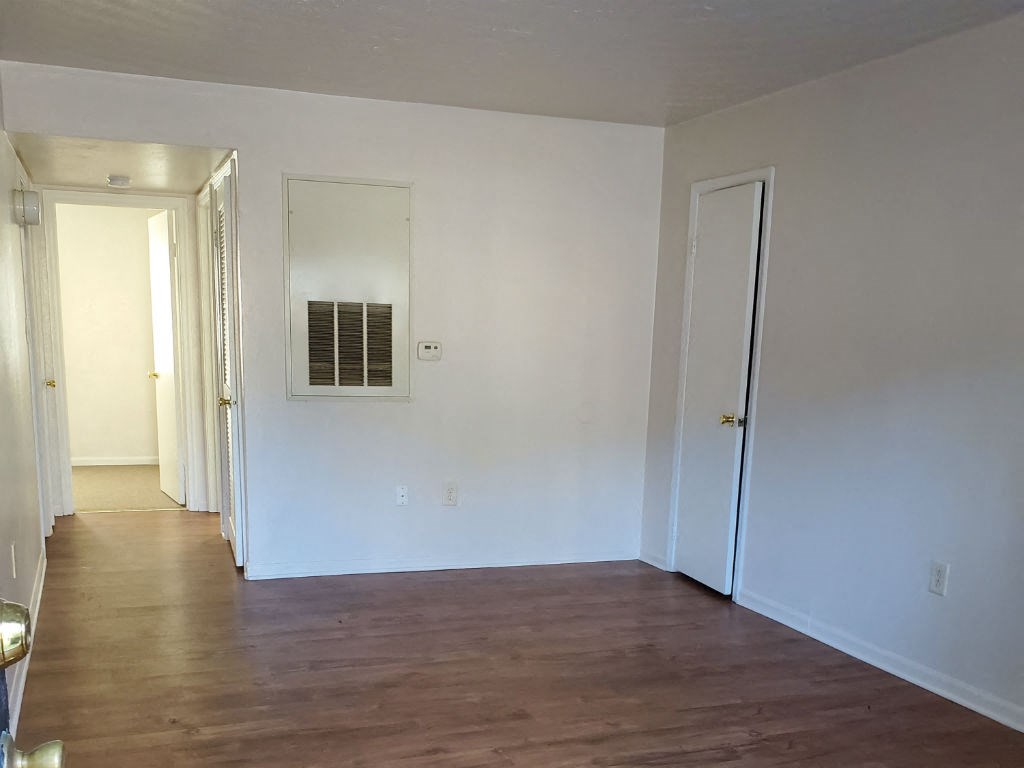 an empty room with a hard wood floor and white walls