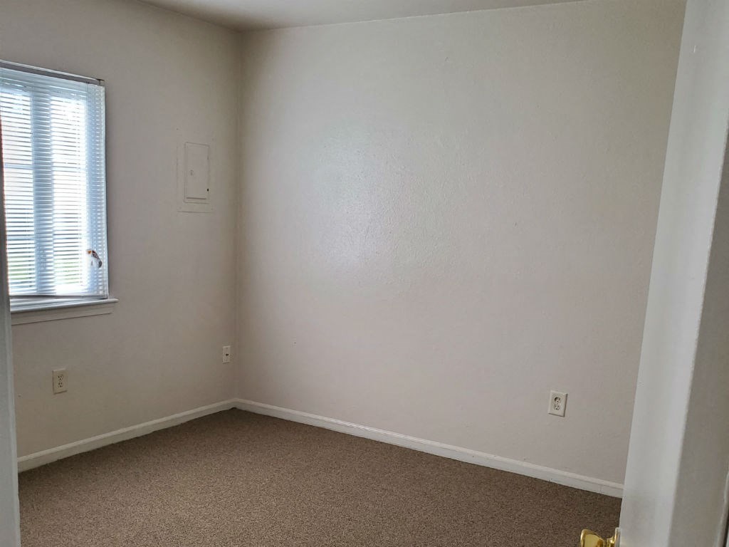 an empty room with a window and a carpet