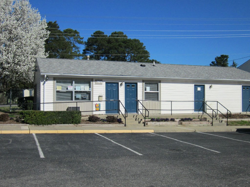 a white building with blue doors and a parking lot