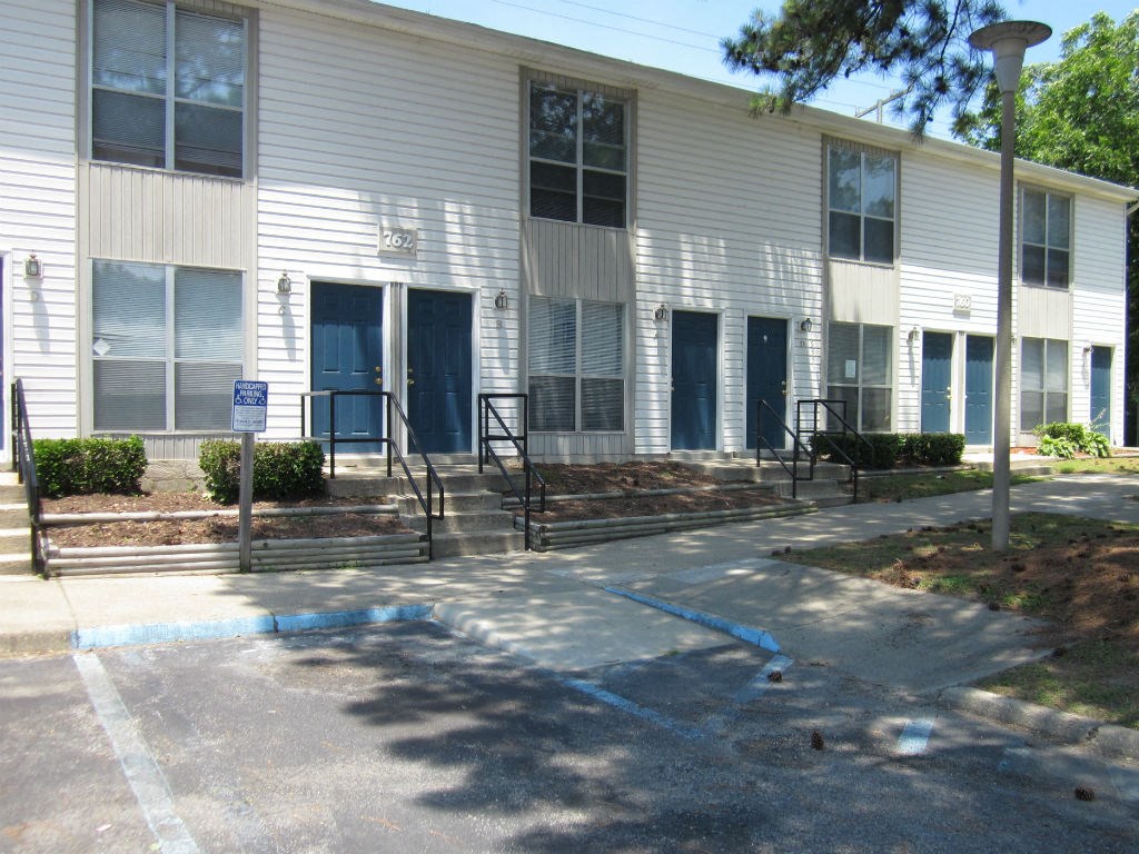 the front of a white building with blue doors