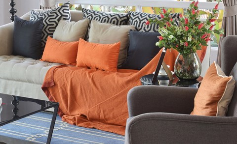 a living room with a couch and a table with a vase of flowers