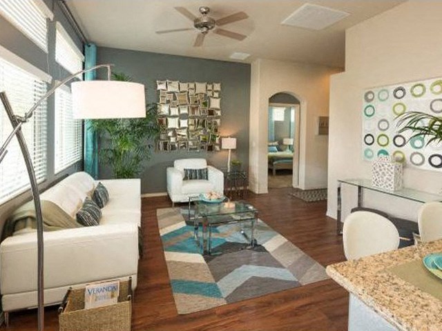 a living room filled with furniture and a ceiling fan