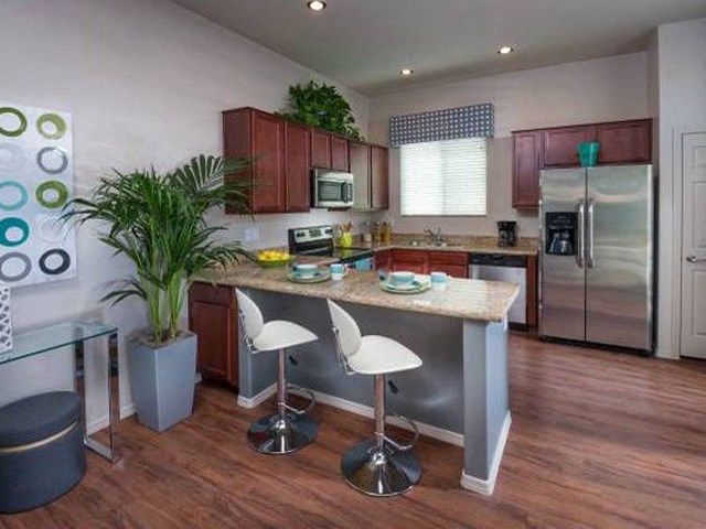 a kitchen with a island and a stainless steel refrigerator