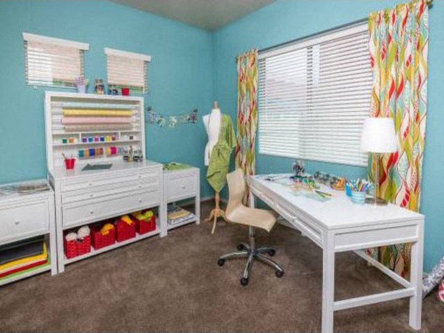 a bedroom with a desk and a chair and a dresser