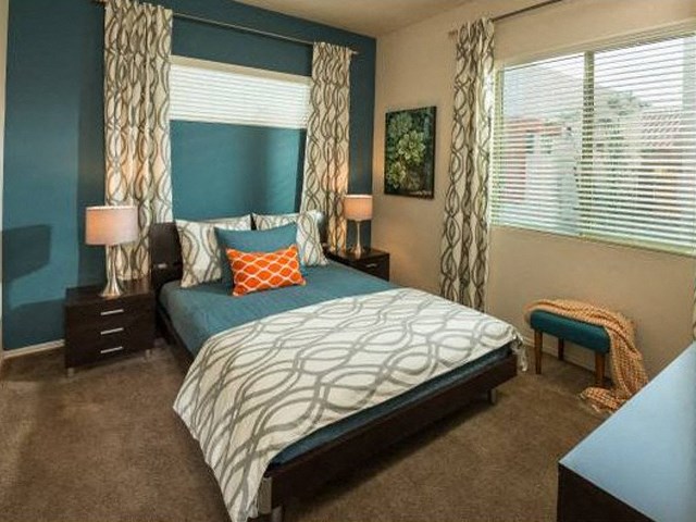 a bedroom with a bed and two windows