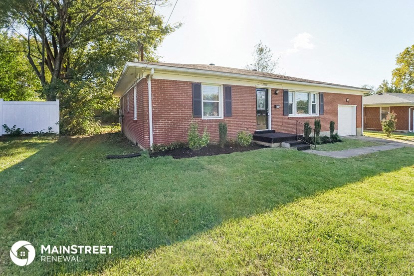 a small brick house with a lawn and a patio