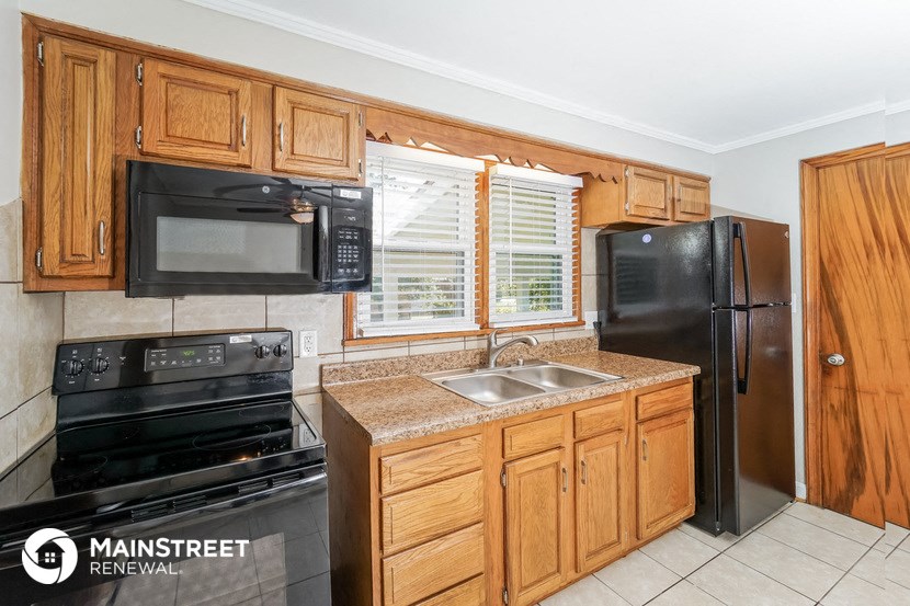 a kitchen with black appliances and wooden cabinets