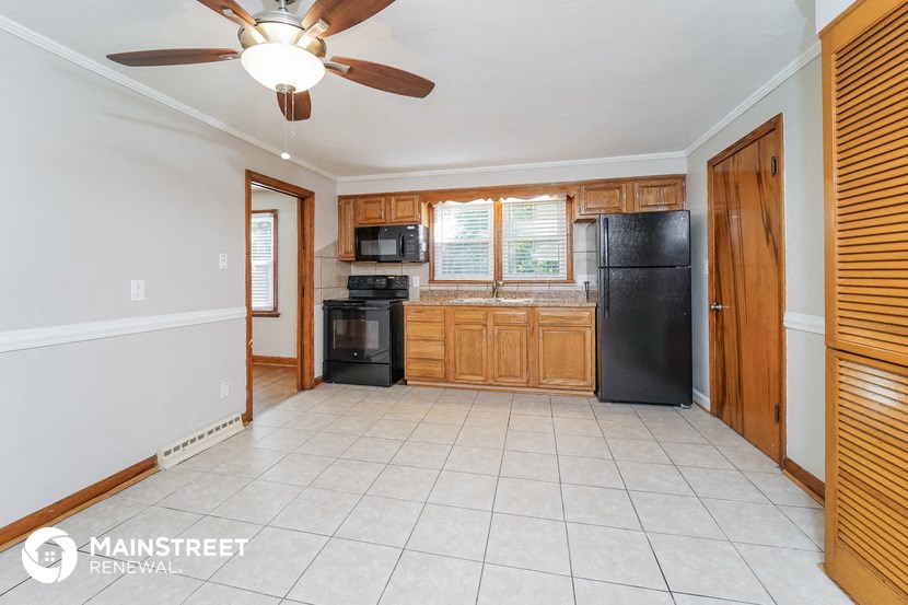 a kitchen with wooden cabinets and a black refrigerator