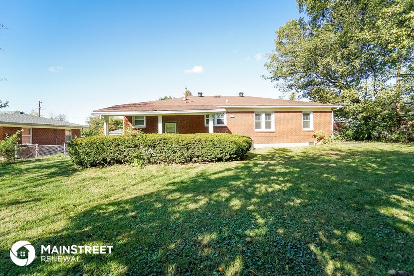 a brick house with a lawn and a tree