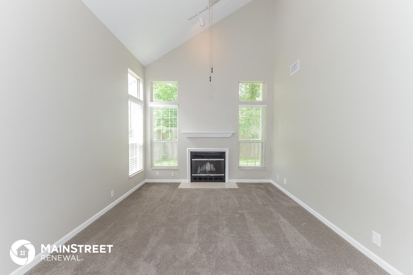 the living room has a fireplace and carpeted flooring