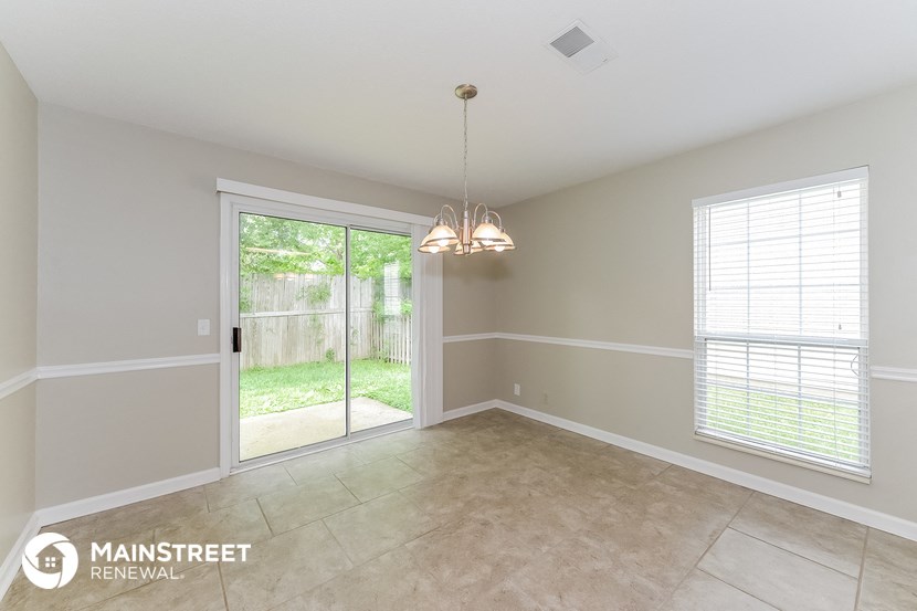 an empty dining room with a sliding glass door to the backyard