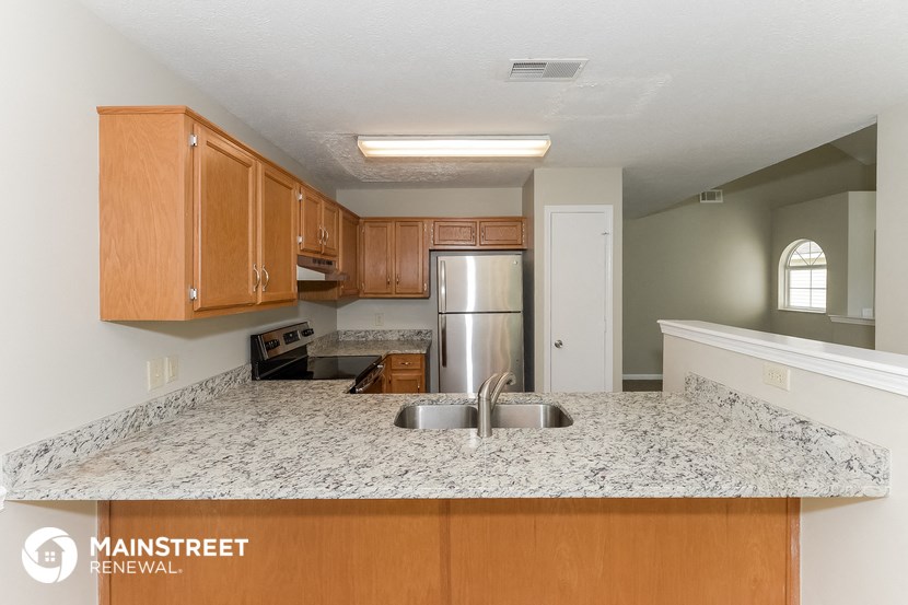 a kitchen with a granite counter top and a stainless steel refrigerator