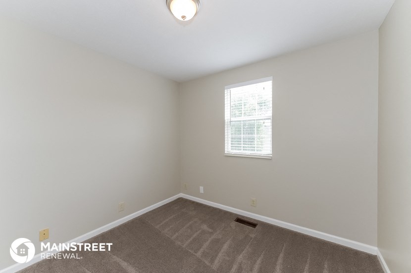 the upstairs bedroom with carpeted flooring and a window