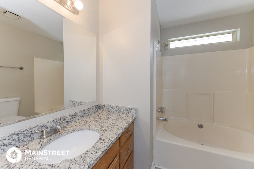a bathroom with a tub and a sink and a mirror