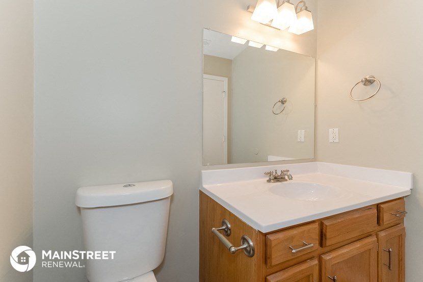 a bathroom with a toilet and a sink and a mirror