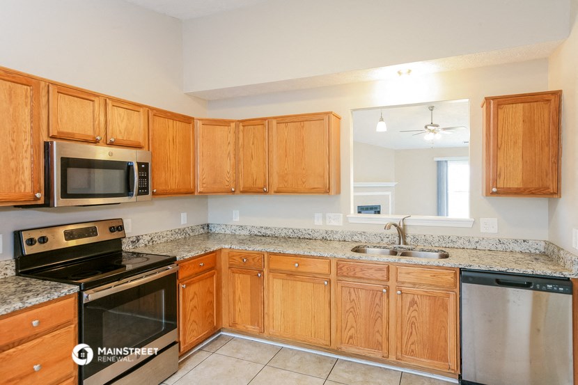 a kitchen with wooden cabinets and granite counter tops