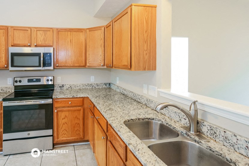 a kitchen with wooden cabinets and granite counter tops and a sink