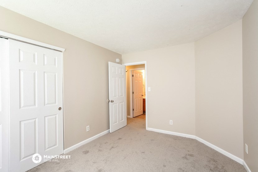 a bedroom with two closets and a door to a hallway