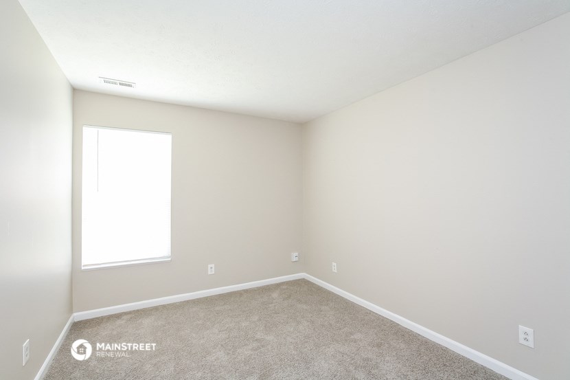 an empty room with carpet and a window