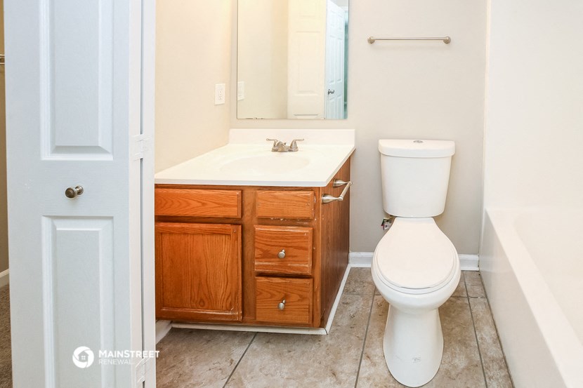 a bathroom with a toilet and a sink and a mirror