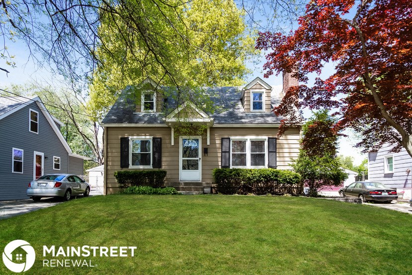a house with a yard and a car parked in front of it