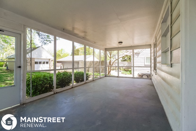 the interior of a screened in porch of a house