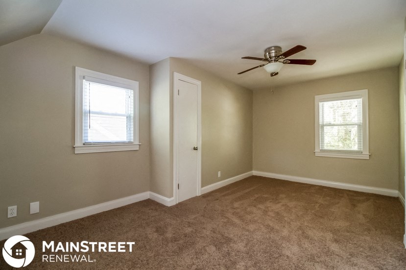 a bedroom with carpet and a ceiling fan