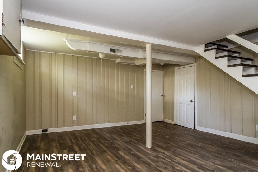 the living room of a renovated house with wooden floors and a staircase