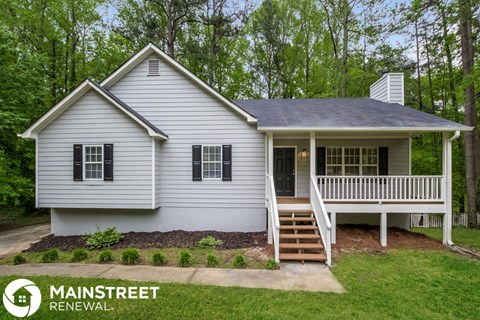 a white house with a front porch and a porch swing